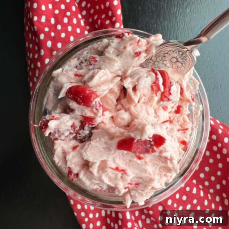 Overhead shot of vibrant whipped cherry butter in a jar, ready to be spread
