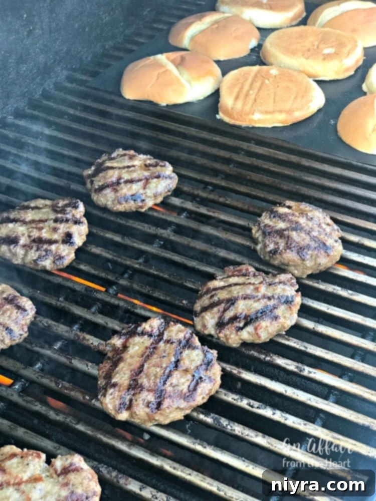 Grilling Italian Burger patties and toasting garlic bread buns on a grilling mat