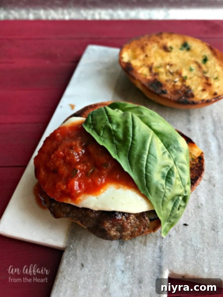 Assembling the Italian Burger with melted cheese and fresh basil