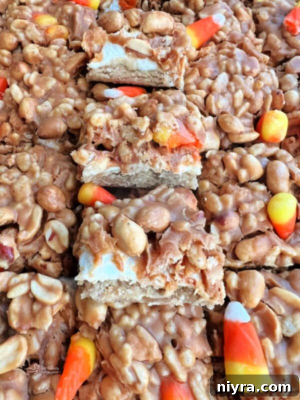 Close-up of Candy Corn Salted Nut Roll Bars, showing layers of crust, marshmallows, peanut butter mixture, and candy corn.