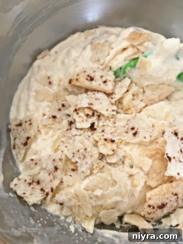 Folding broken pie crust pieces into the apple blizzard mix