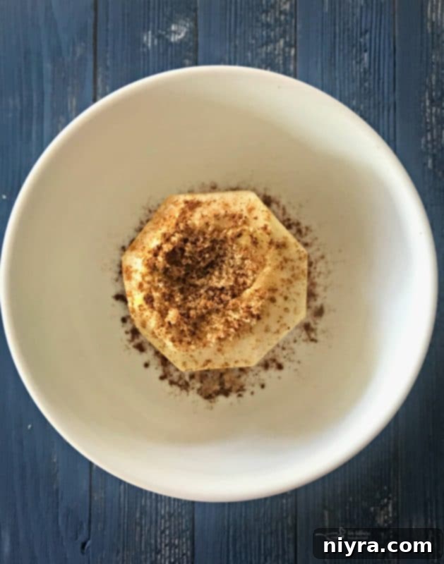 Apple sprinkled with cinnamon and nutmeg, ready for microwaving