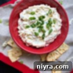Overhead of swiss cheese dip in a red bowl