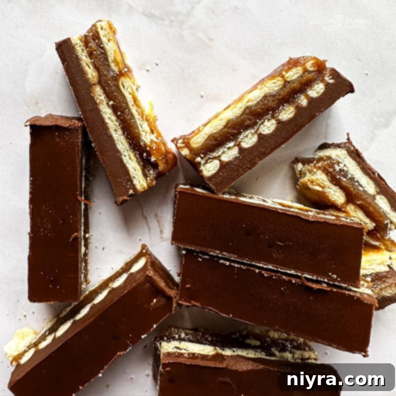 Triple Layer Chocolate Caramel Delight 14 A tray of freshly made homemade Twix bars, some sliced, some still whole, showcasing the rich texture and multiple layers.