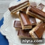 Triple Layer Chocolate Caramel Delight 20 Homemade Twix Bars stacked on a white serving plate
