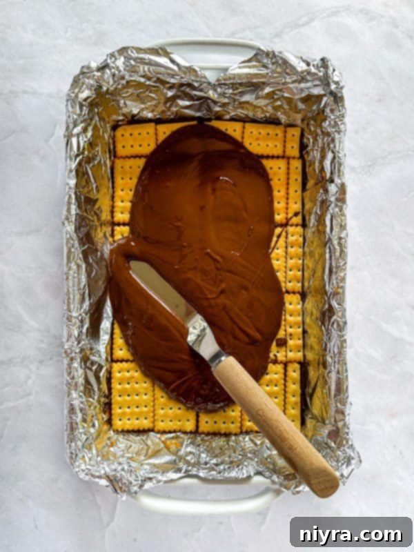 Triple Layer Chocolate Caramel Delight 9 Chocolate chips and peanut butter melting together in a small saucepan, being stirred until smooth.