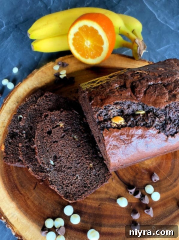 Sliced Chocolate Orange Banana Bread on a cutting board, showing moist texture and chocolate chips