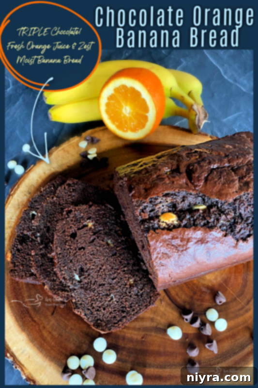 A tall, narrow loaf of Chocolate Orange Banana Bread, perfectly baked