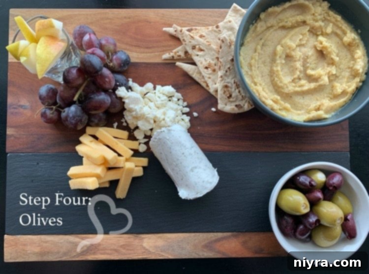 Step four of building a Mediterranean Cheeseboard: adding olives