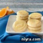 Orange Meltaway Cookies stacked on a white plate