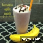 Banana split malt in a large glass with a straw with a banana next to it and text 'banana split malt'