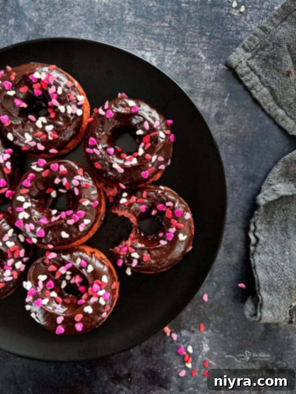 A beautifully arranged platter of baked chocolate covered strawberry donuts, ready to be served.