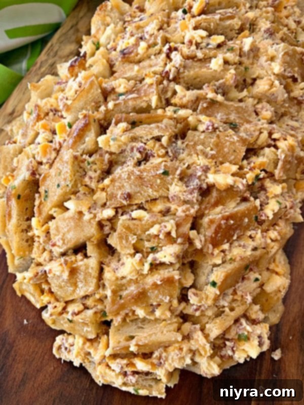 Stuffing the cheesy bacon mixture into the cracks of the sourdough bread