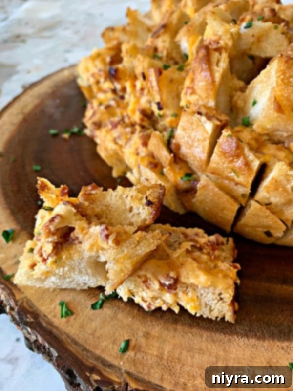Two pieces of baked Dorothy's Cheesy Bacon Pull-Apart Bread showing the rich filling