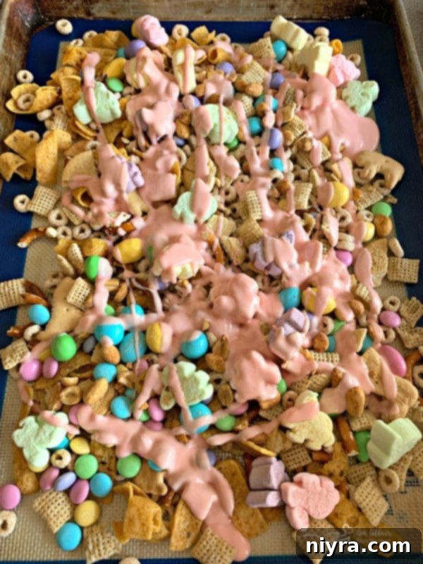 Sweet Springtime Medley 6 Melted almond bark being poured over the dry snack mix ingredients.