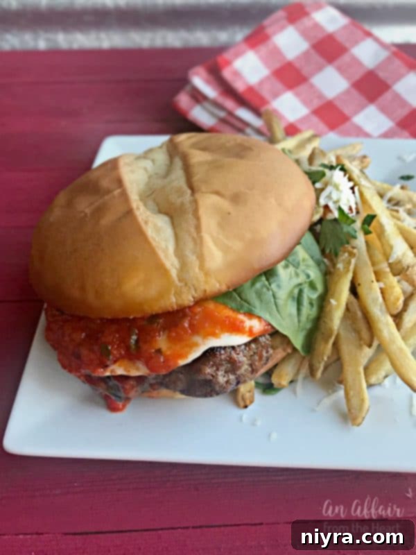 Italian Burger served with french fries on a white plate
