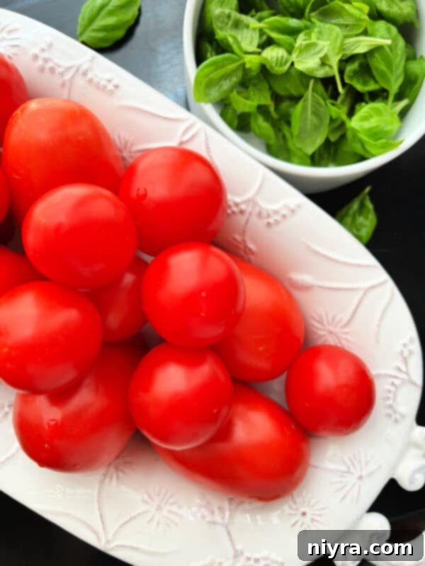 Hand arranging fresh mozzarella and basil with tomatoes