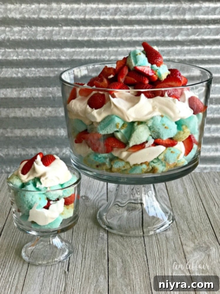 Vibrant Red, White, and Blue Strawberry Shortcake Trifle with layers of blue angel food cake, whipped cream, and fresh strawberries