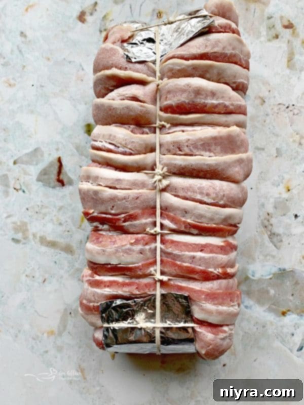 Bacon Wrapped Pork Loin tied with butcher's twine, ready for the smoker.