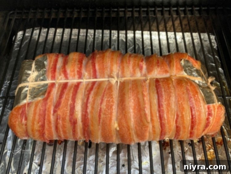 Bacon Wrapped Pork Loin smoking on a Traeger grill.