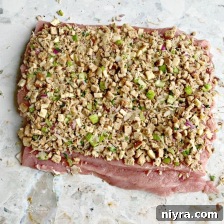 Butterflied pork tenderloin with sauerkraut stuffing spread evenly on top.