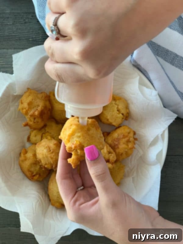 Corn fritters served with a squeeze bottle of honey.