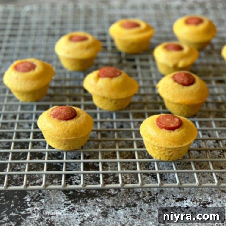 Corn Dog Mini Muffins cooling on a wire rack, freshly baked