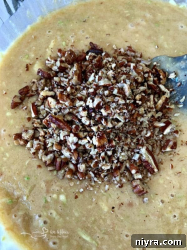 Folding in chopped nuts into Zucchini Bread batter