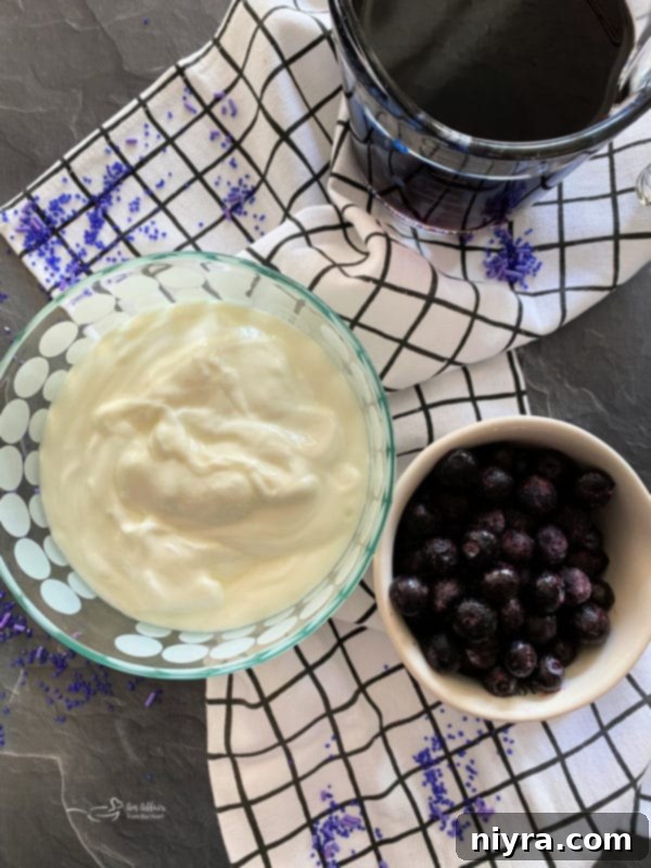 Top view of yogurt, blueberries, and grape juice – key ingredients for purple cow smoothie