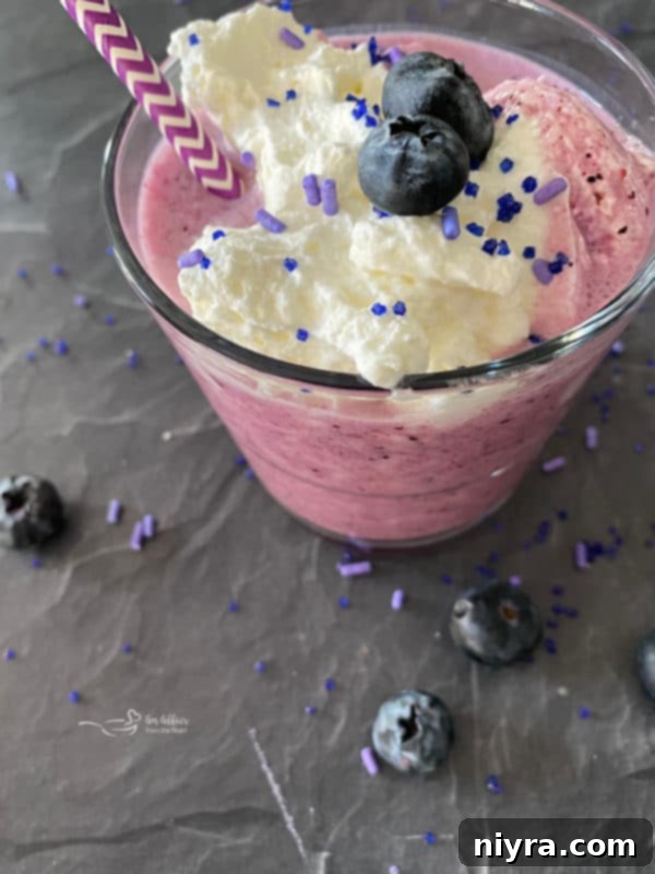 Top view of purple cow smoothie with whipped cream and berries – delicious and ready