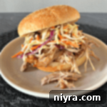 Close up of Crock Pot Pulled Pork with Dorothy Lynch Coleslaw on a white plate