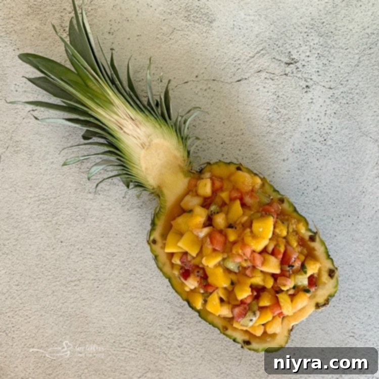Tropical Salsa presented beautifully in a hollowed-out fresh pineapple half, creating a natural and festive serving bowl.