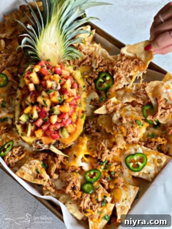 A glorious close-up of Tropical Chicken Nachos, showcasing the melted cheese, tender chicken, and fresh garnishes, truly a winning dish.