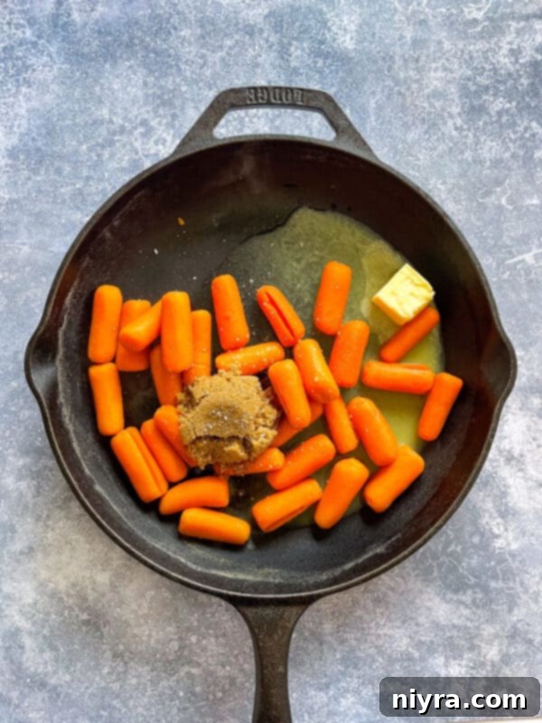 Step-by-step image showing baby carrots covered with water in a saucepan.