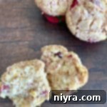 Overhead view of Cranberry Orange Muffins; one muffin is cut in half to show its interior