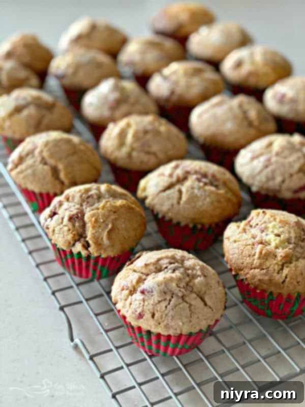 Freshly baked Cranberry Orange Muffins cooling on a wire rack, steam gently escaping