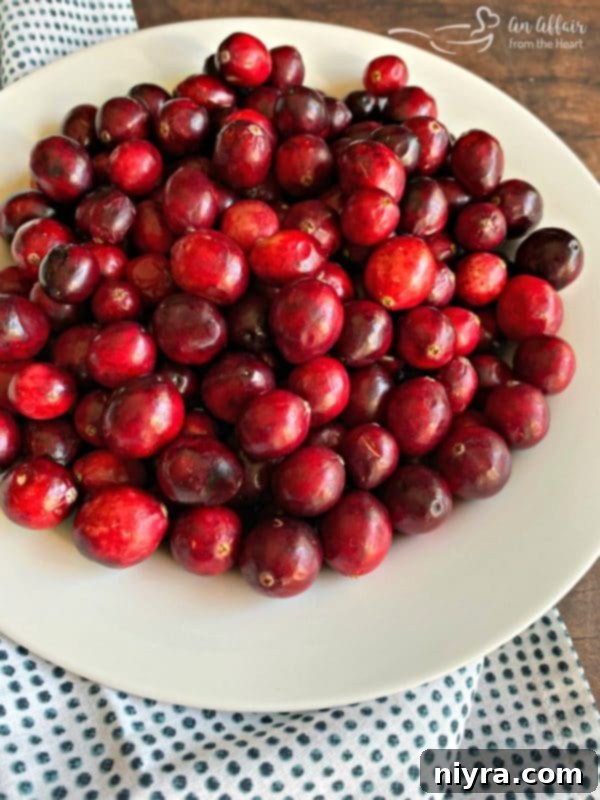Ingredients for Mom's Cranberry Sauce being prepared, showing fresh cranberries and vibrant orange zest