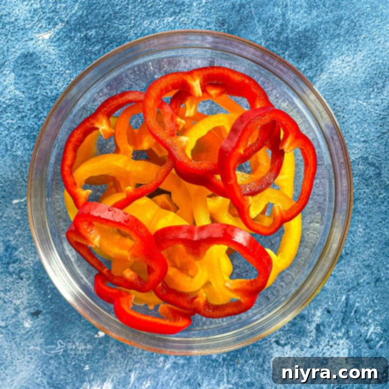 Vibrant assortment of bell peppers in a bowl, ready for slicing.