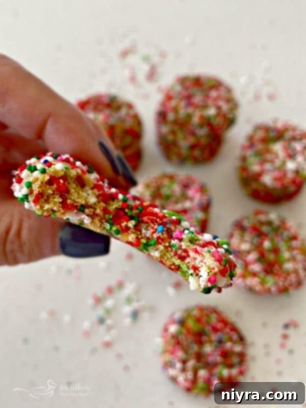 Close up of a Funfetti Sugar Cookie with a bite taken, showing sprinkles inside