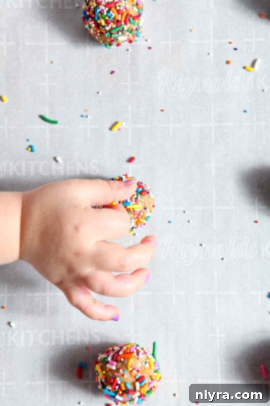 Overhead shot of Funfetti cookie dough preparation with child's hands