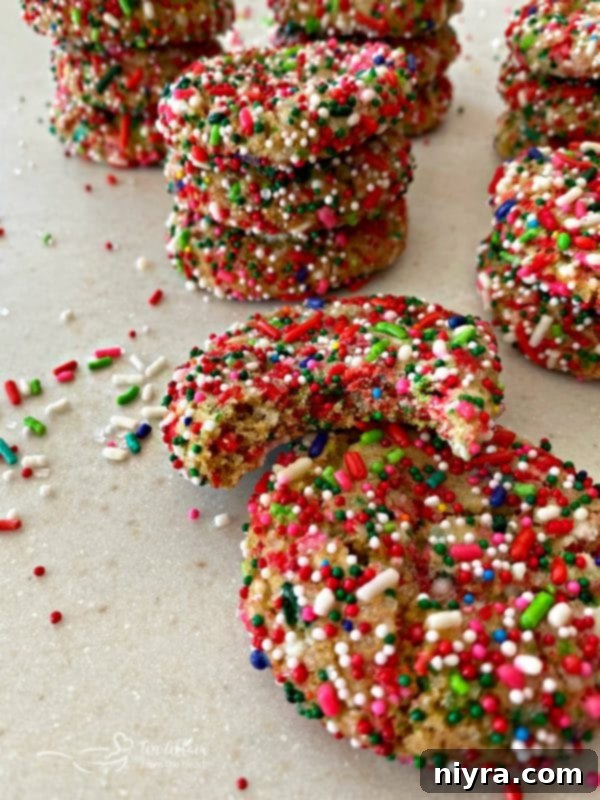 Stack of Christmas Funfetti Sugar Cookies with a bite taken out of one