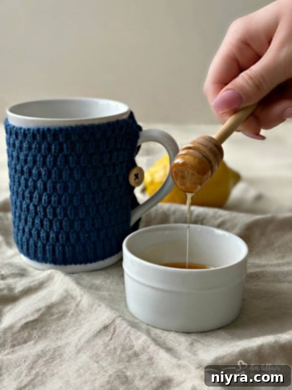 Honey being stirred into a Starbucks Medicine Ball Tea