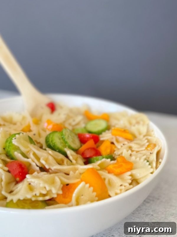 Close-up of Easy French Vinaigrette Pasta Salad with bowtie pasta, cucumbers, bell peppers, and tomatoes
