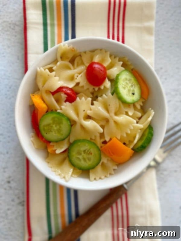 Small bowl of Easy French Vinaigrette Pasta Salad on a striped napkin