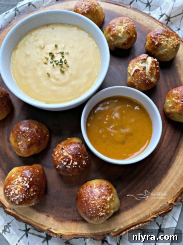 Sausage Pretzel Bombs with Tangy Cheese Dip 2 Delicious Sausage Pretzel Bombs with Mustard Cheese Sauce on a serving platter