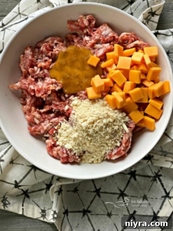 Sausage Pretzel Bombs with Tangy Cheese Dip 9 Sausage Stuffed Pretzel Bombs prep: Mixing ingredients for meatballs