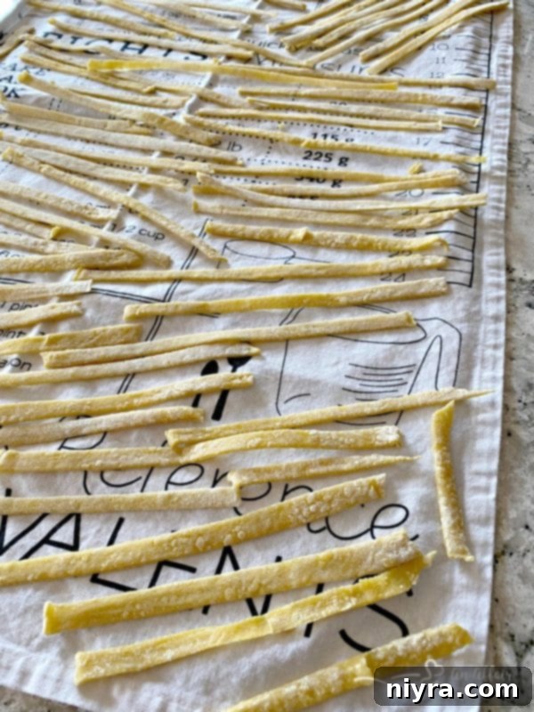 Homemade egg noodles drying on a kitchen towel