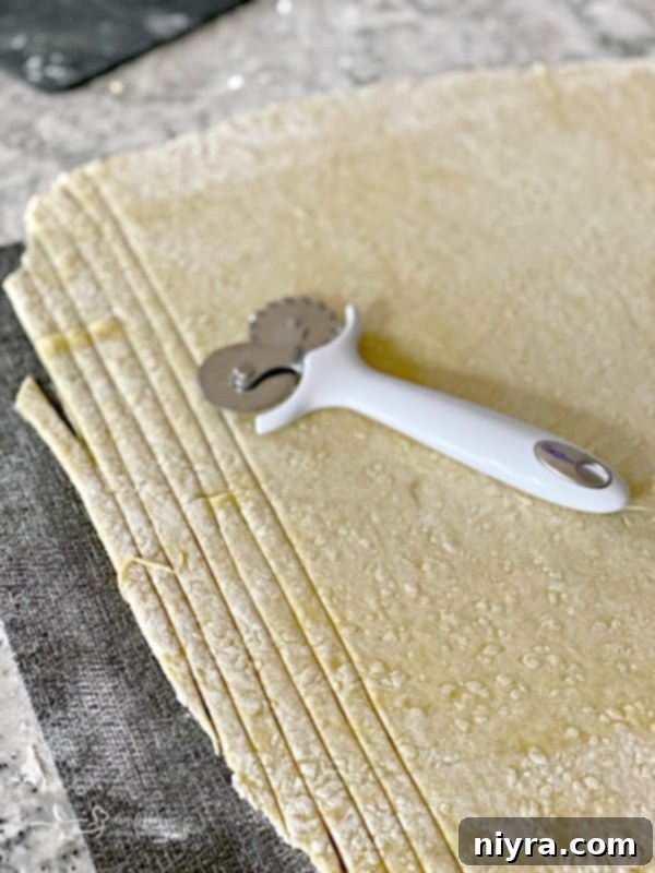 Cutting homemade egg noodles with a pastry cutter