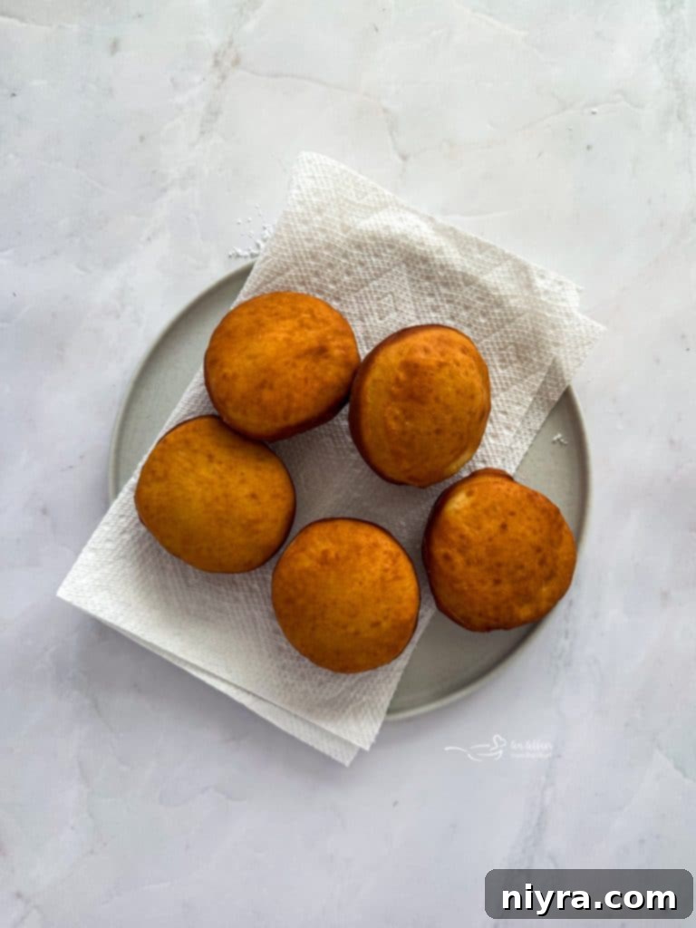 Pączki: The Ultimate Polish Donuts Video 12 Oil heating in a cast iron Dutch oven, with raw Paczki dough rounds nearby.