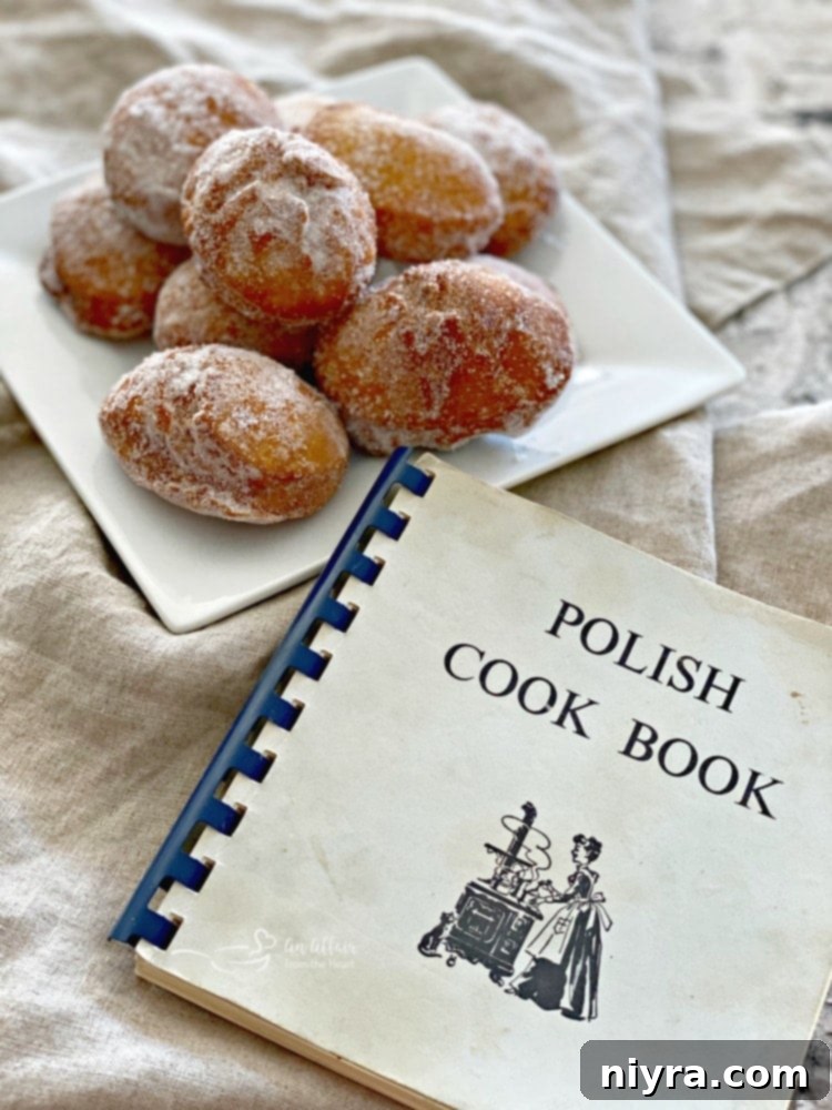 Pączki: The Ultimate Polish Donuts Video 17 Pączki - Polish Donuts on a white plate next to an old Polish Cookbook.